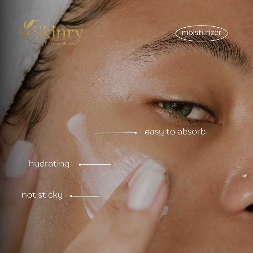 Close up of woman applying almond and kesar moisturizer to cheek showing hydrating easy to absorb feel