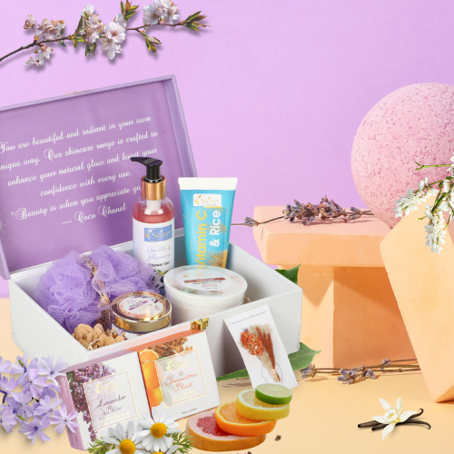 luxury bath gift set in pastel box with purple loofah, body lotion, creams, soap slices, pink bath bomb, and flowers