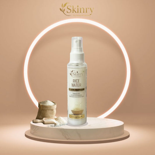 Skinry rice water toner for face spray bottle on marble pedestal with rice sack scoop and glowing ring light